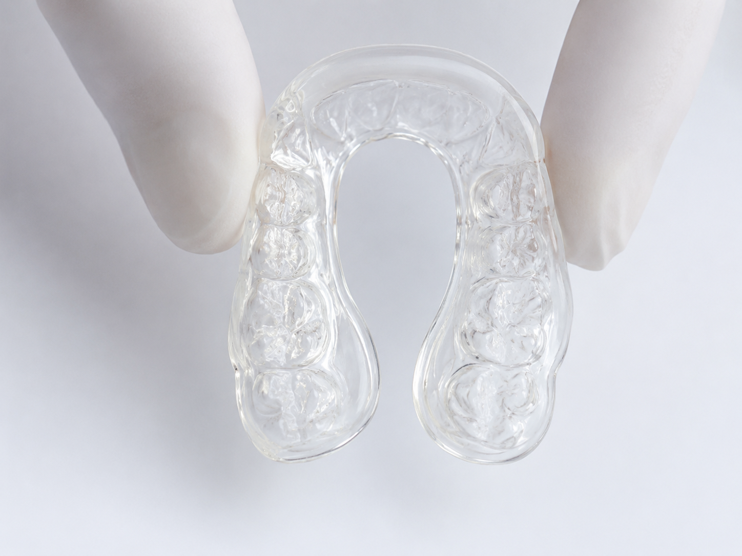 Férula blanda transparente sostenida con guantes clínicos